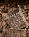 rattan log basket in front of wood pile