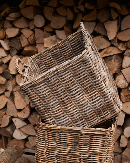 rattan log basket in front of wood pile