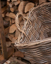 rattan log basket in front of wood pile. handle detail