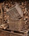 handmade  weaved rattan log basket  against wood pile