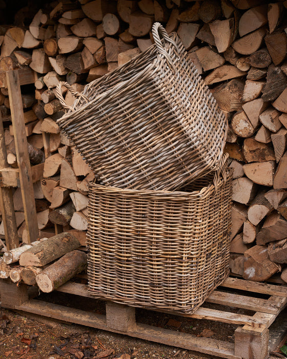 handmade  weaved rattan log basket  against wood pile