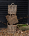 handmade  weaved rattan log basket  against wood shed 