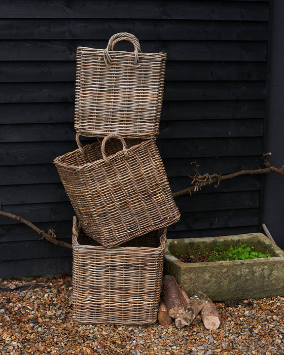 handmade  weaved rattan log basket  against wood shed 